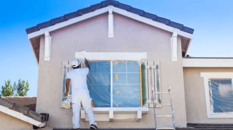 Homem pintando fachada da casa